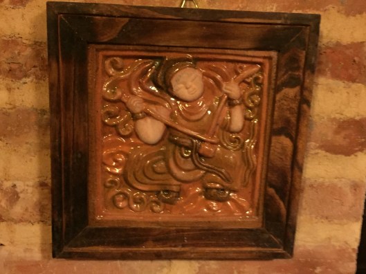 A glazed ceramic wall hanging.