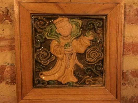 A Buddhist monk glazed in a ceramic wall hanging.