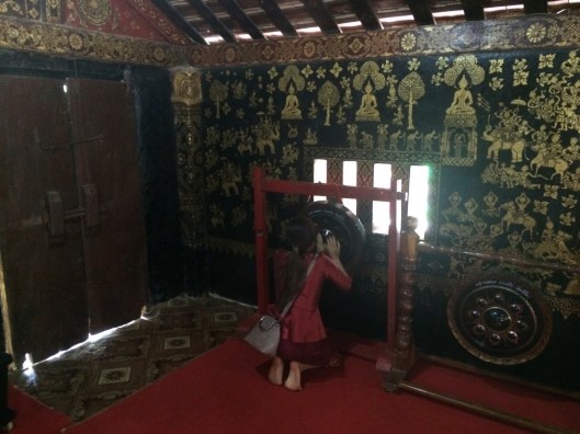 A young woman rubs a gong for positive energy, in the same room as Obama's gong strokes for 